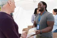 Handing over a donation box at a community drive